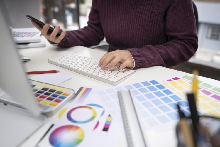 young-female-designer-checking-her-smartphone